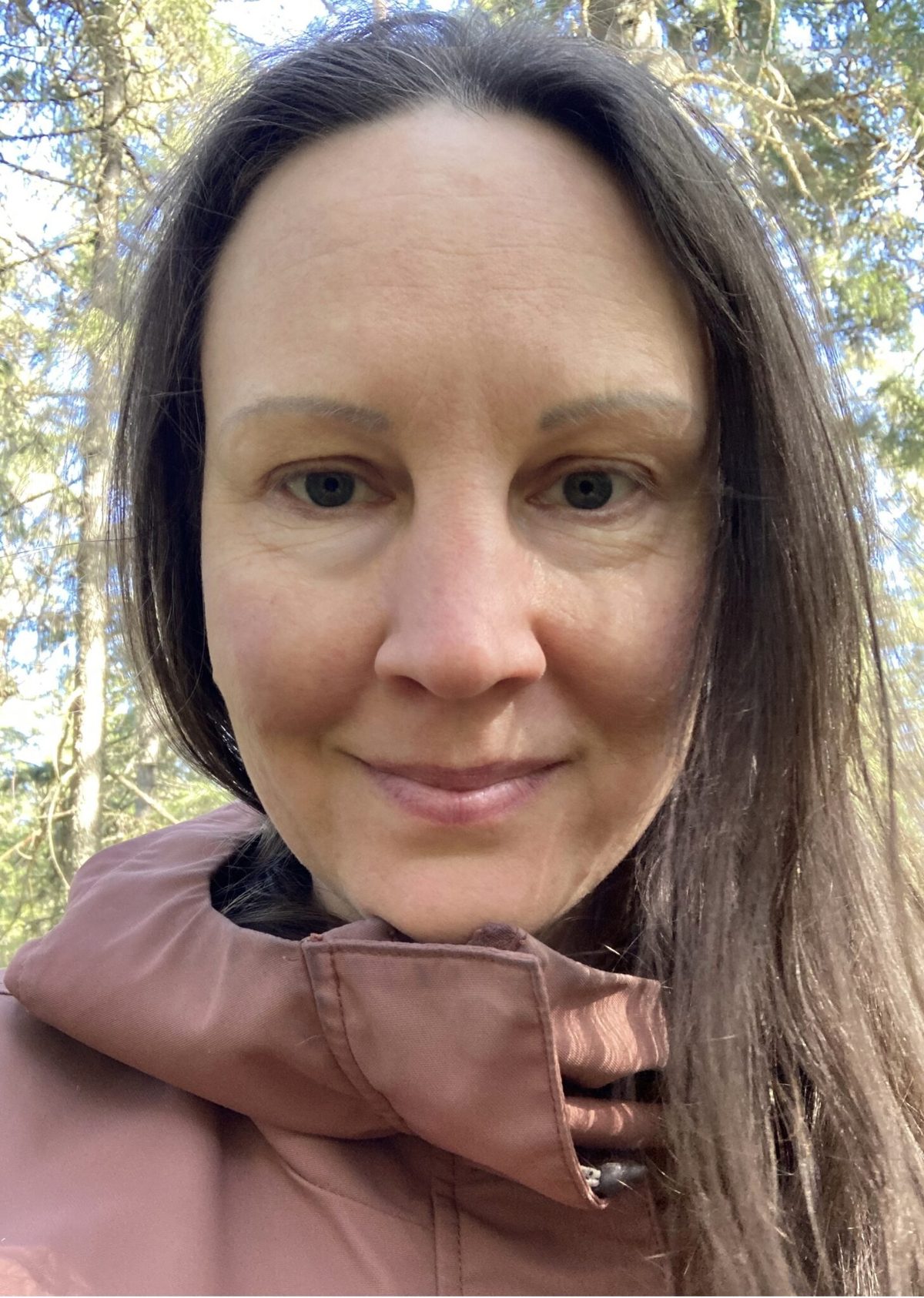 Johanna metsässä, hymyilee kameralle